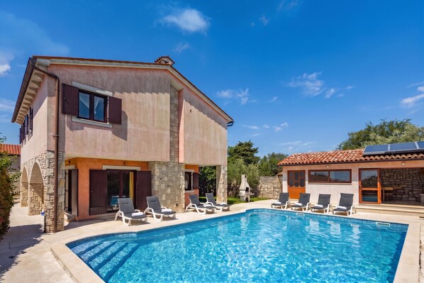 A two-story house with a swimming pool, stone walls, and a separate building with a tiled roof. - Pool House Suzi in Heart of Istria (Barban)