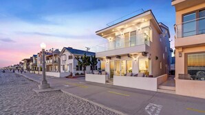 A beachfront property with a modern design, featuring a flat roof, large windows, and a balcony. - OCEANFRONT MODERN LUXURY W/ROOFTOP (Newport Beach)