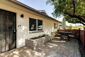 A house with a patio, a black gate, and a brick wall. - Casa De Los Caballeros (Scottsdale)