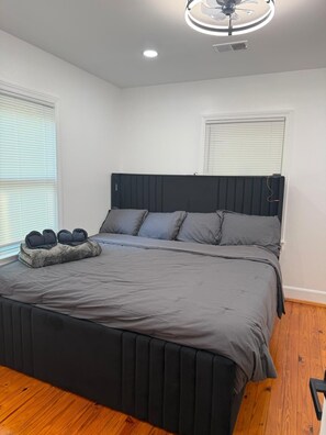 A bedroom with a bed, a ceiling fan, and two windows with blinds. - Peaceful 3-bedroom house with AC in lovely Tucker (Tucker)