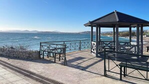 A coastal gazebo with a view of the sea, a stone wall, and a paved walkway. - Upscale Sea-View Apartment in Athenian Riviera (Paleo Faliro)