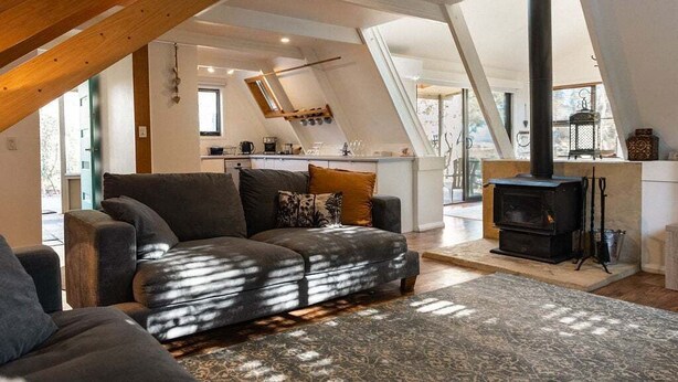 Ein Wohnzimmer im Loft-Stil mit einer Couch, einem Kamin und einer Küchenzeile.