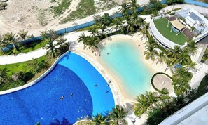 A resort with a large pool, a beach area, and palm trees. - Family One Bedroom with Manmade Beach View & Mt Arayat View (San Fernando)