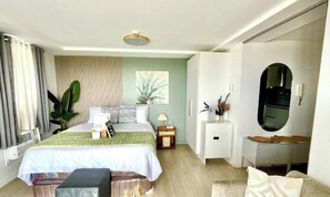 Un dormitorio con cama, mesita de noche, lámpara y espejo.