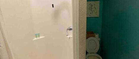 Een badkamer met een bad, toilet en douchekop.