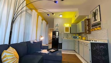 Un salon moderne avec un canapé, une table basse et une vue sur la cuisine.