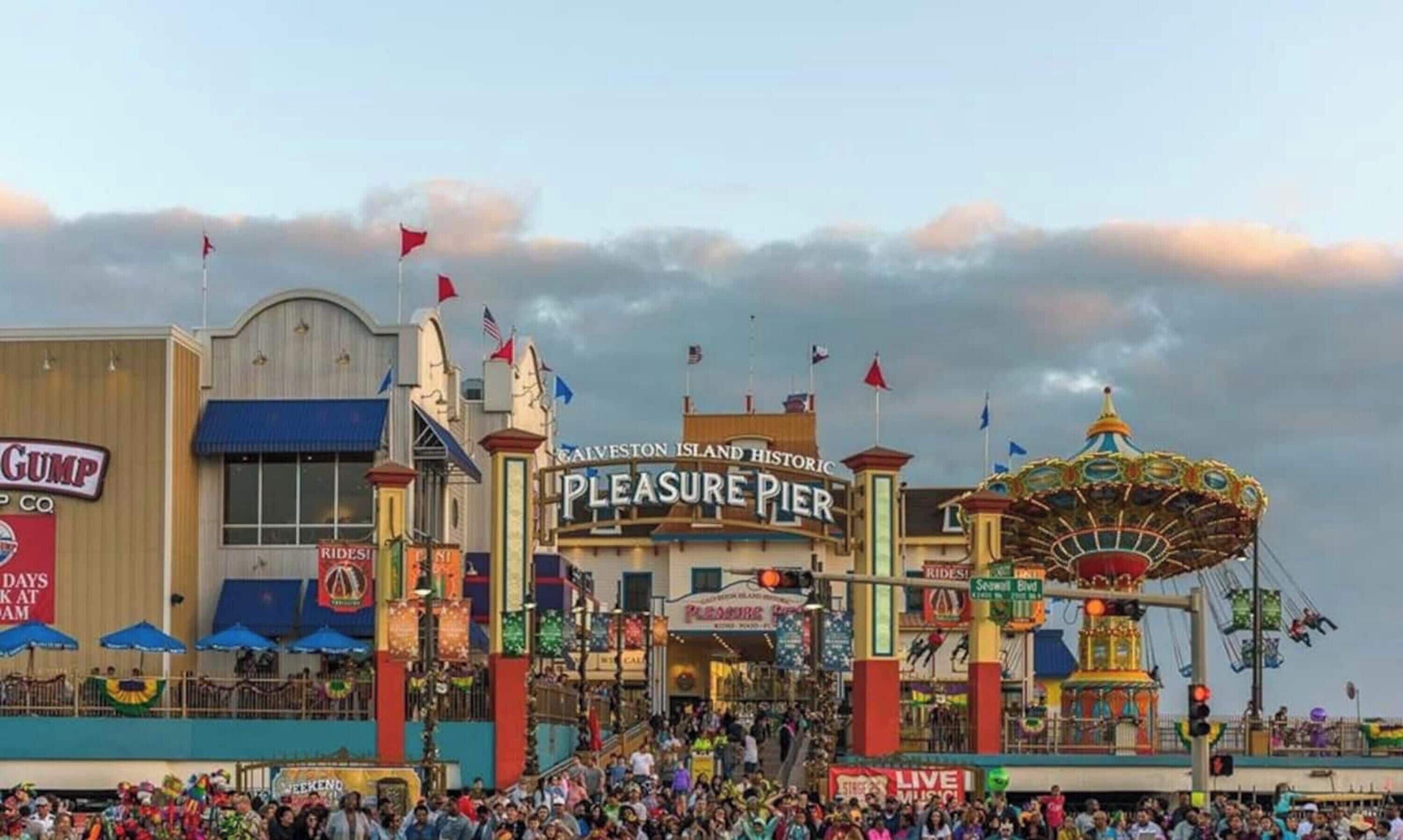 A historic pier with a carousel and a sign for 'Pleasure Pier.'