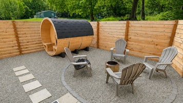 Een terras met houten meubels en een vat.