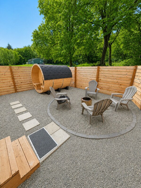 An outdoor seating area with wooden furniture and a barrel.