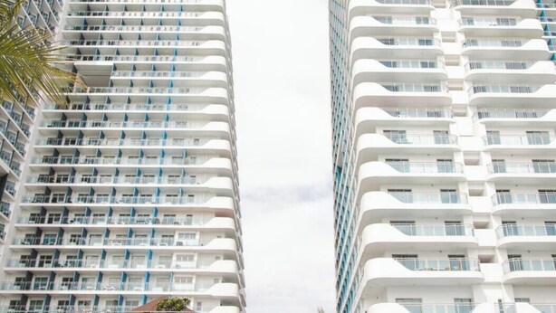 Twee hoge gebouwen met balkons, waarschijnlijk onderdeel van een hotelcomplex.