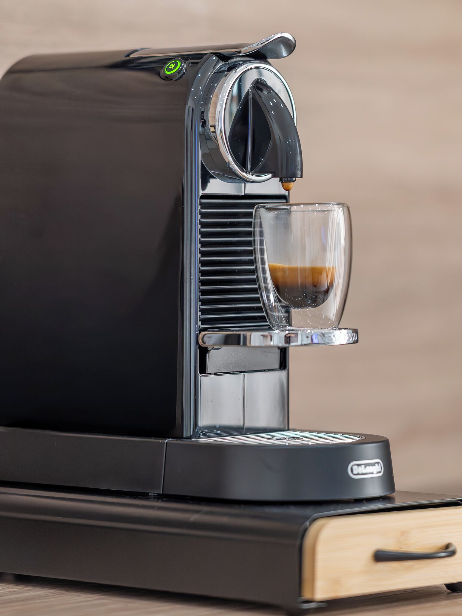 Eine Kaffeemaschine mit einem Glaskelch, einer Bedienblende und einem Markenzeichen.