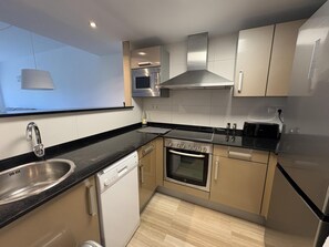 Eine moderne Küche mit Geschirrspüler, Backofen, Mikrowelle und eingebautem Toaster.