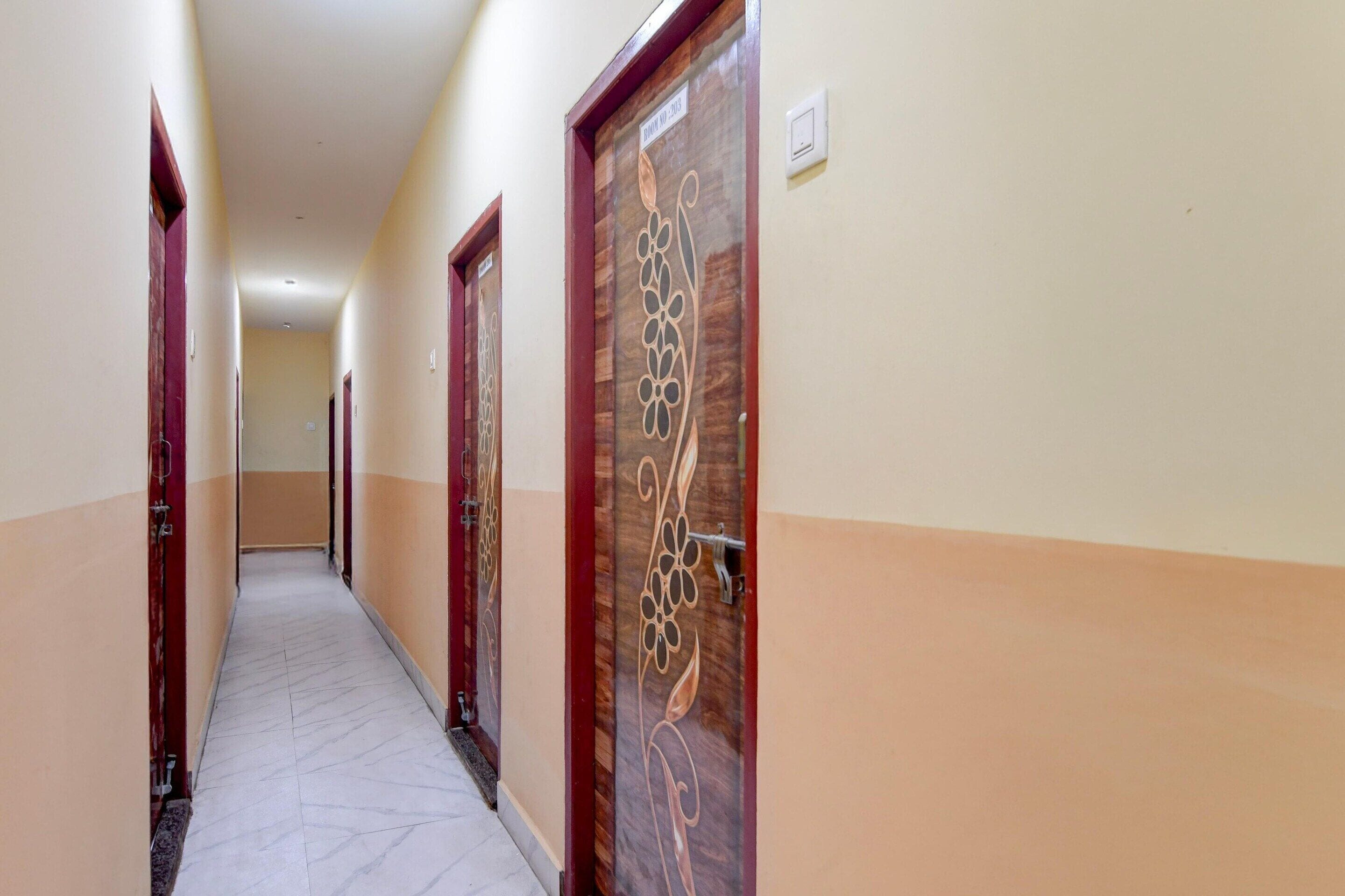 A hotel corridor with doors, a marble floor, and a light switch on the wall.