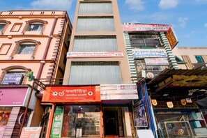 Ein mehrstöckiges Gebäude mit verschiedenen Geschäften, darunter ein Gästehaus und eine Apotheke.