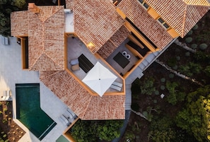 A rooftop with a pool, outdoor seating, and a hot tub.