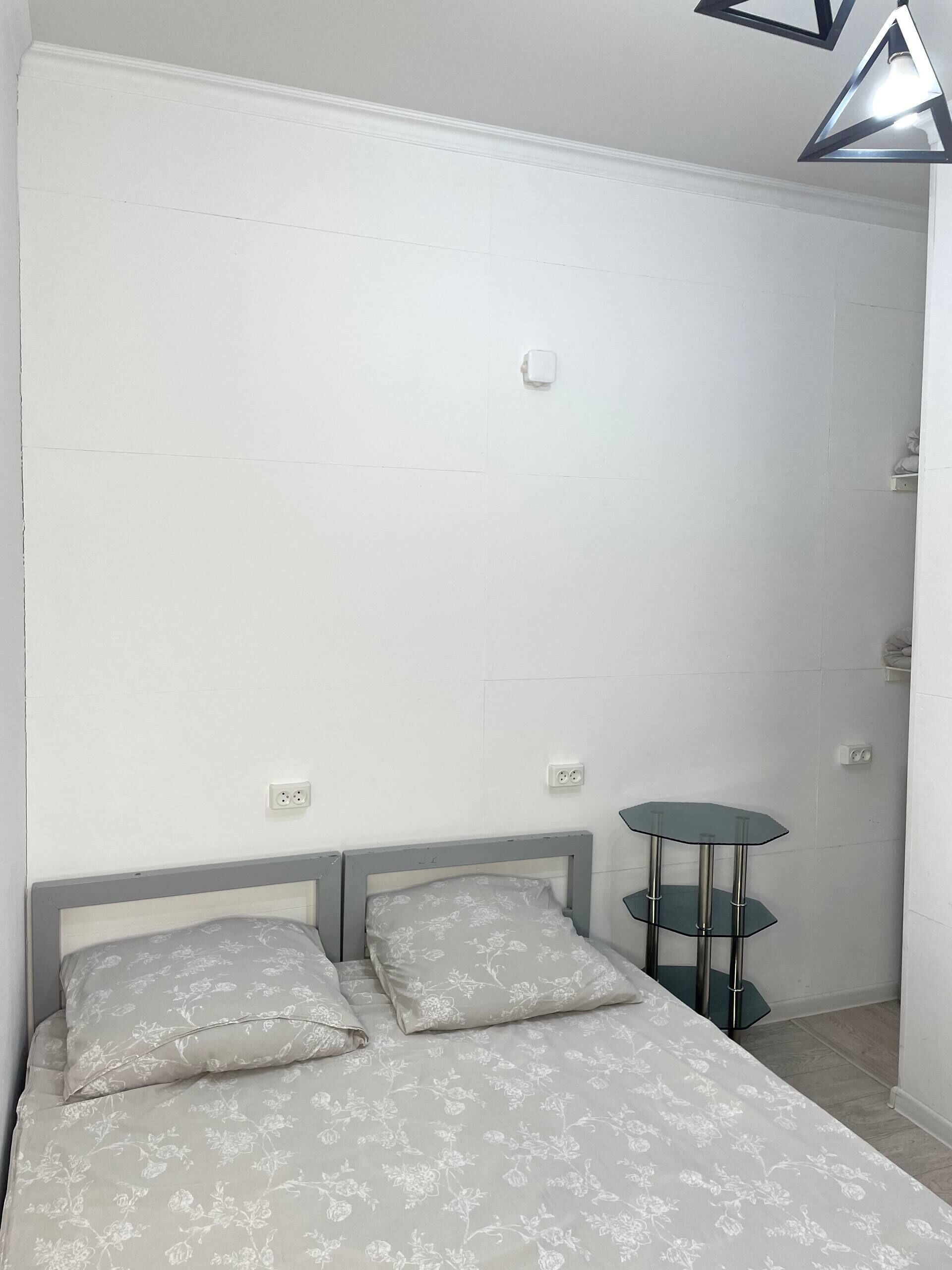 Een slaapkamer met een bed, twee nachtkastjes en een kledingkast.