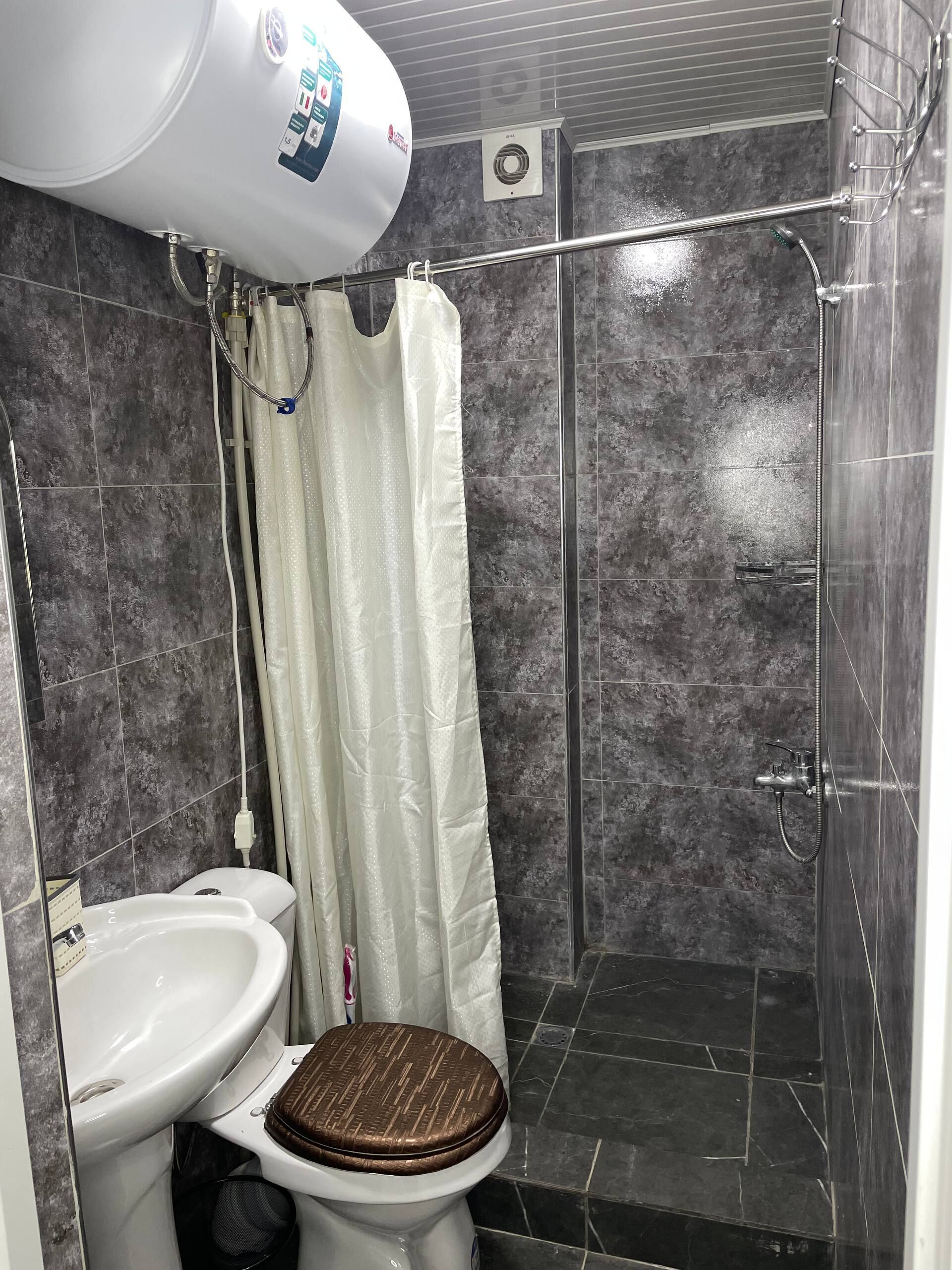 Ein Badezimmer mit Dusche, Toilette und Waschbecken.