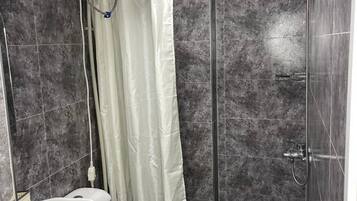 Ein Badezimmer mit Dusche, Toilette und Waschbecken.