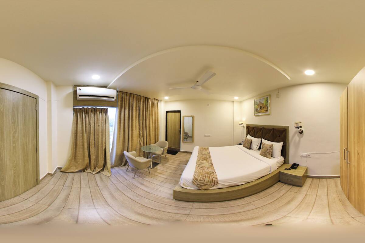 A bedroom with a curved ceiling, a bed, a desk, and a chair.