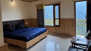 Un dormitorio con una cama de madera, una mesita y un balcón con vistas al exterior.