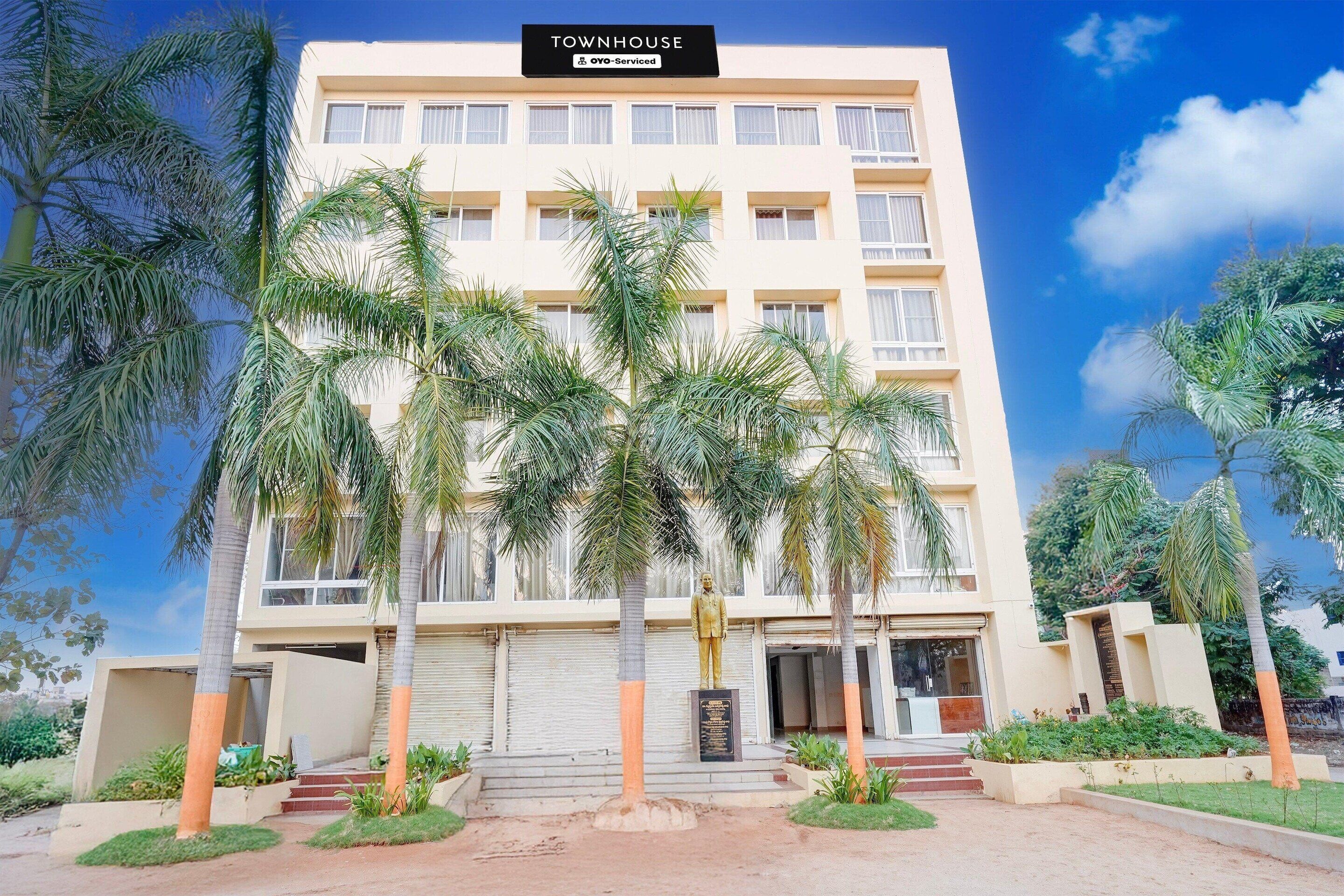 Un edificio de varios pisos con un letrero que dice 'TOWNHOUSE OYO-Serviced'.