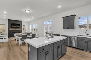 A modern kitchen with grey cabinets, a white countertop, and a built-in oven. - Timpanogos View Retreat with RV Parking Pad (Heber City)