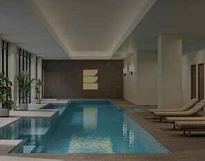 An indoor swimming pool with lounge chairs and potted plants. - Relaxing 2BR with Lake Views in Eastbourne (Parkes)