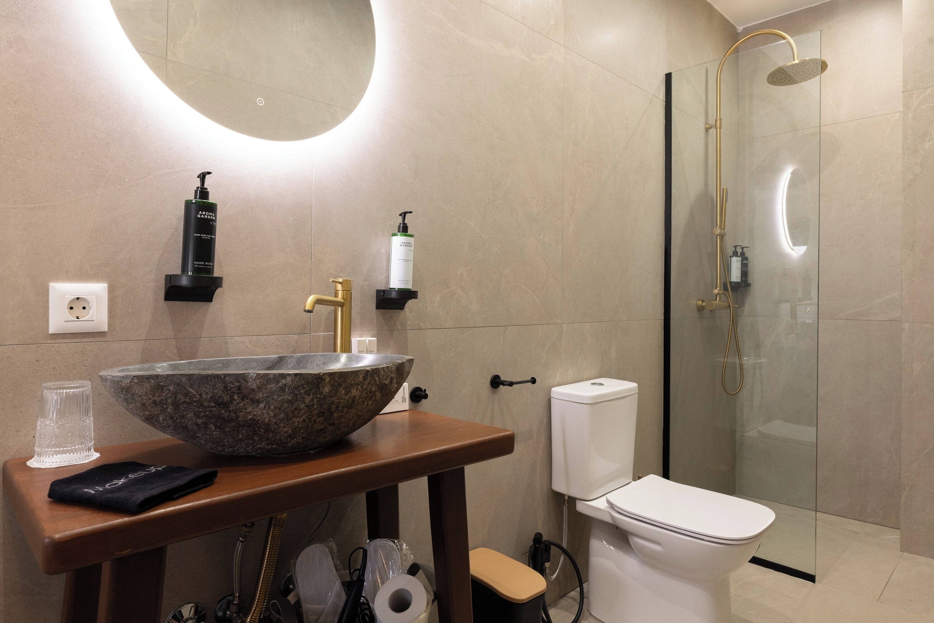 Et moderne badeværelse med en stor skål-vask, et toilet og en brusekabine med glasvægge.
