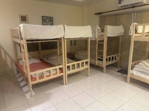 A room with bunk beds, a tiled floor, a wardrobe, and a picture on the wall. - Bursa Hotel (Patong)