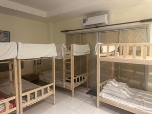 A dormitory room with bunk beds, a wardrobe, and an air conditioning unit. - Bursa Hotel (Patong)