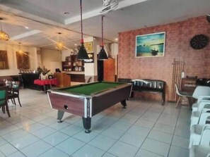 A billiards room with a pool table, chairs, and a dartboard. - Bursa Hotel (Patong)