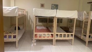 A room with bunk beds, a small table, and a framed picture on the wall. - Bursa Hotel (Patong)