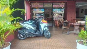 Una fachada con un letrero que dice 'WELCOME' y 'BONANZA PATONG'. Varias motocicletas están estacionadas afuera, y se ve la entrada.