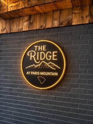 Um letreiro de neon com o texto 'THE RIDGE AT PARIS MOUNTAIN' e um desenho de montanha.