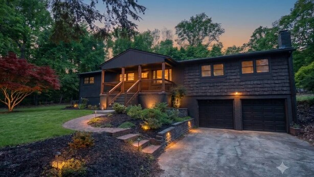 Uma casa moderna de dois andares com varanda coberta, entrada por uma calçada e jardim bem cuidado.