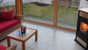 Habitació acollidora amb un sofà, una taula petita i una espelma, i una llar de foc.