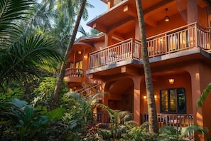 A multi-story building with balconies, surrounded by tropical vegetation. - Wonderland  (Mandrem pernem)