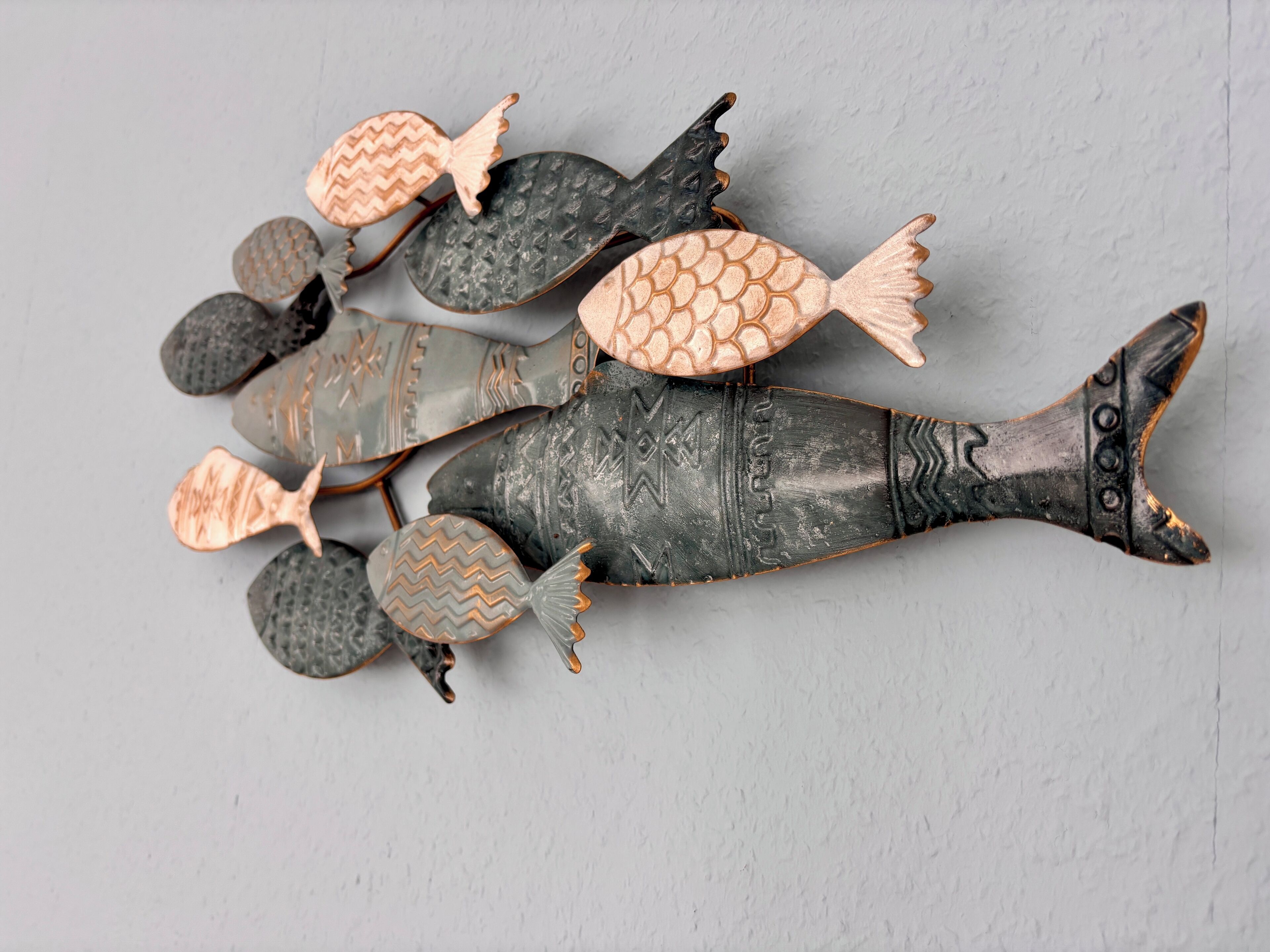 Une sculpture de poisson décorative, dotée de plusieurs têtes de poisson et d’un seul corps de poisson.