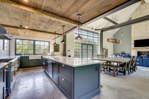 A modern kitchen with a large island, wooden ceiling beams, and pendant lighting. - Luxe Mountain Getaway on Private Rd Near Rhinebeck (Hyde Park)