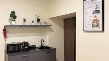 Microondas en la zona común y máquina de café espresso