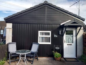 A small black metal shed with a white door, a window, and a welcome sign. - The Highland Studio - NC500's Home from Home (Highland)