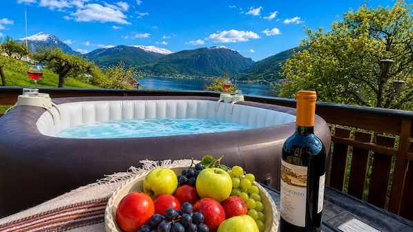 Un bain à remous, une bouteille de vin et un panier de fruits.