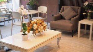 A dining area with a table, chairs, and a sofa. - Nevv City Hotel (İstanbul)