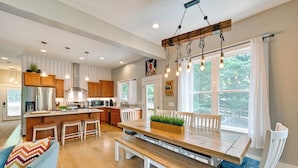 A modern kitchen with wooden cabinets, a central island, and pendant lighting. - Lakehouse Blue: Fire Pit, Hot Tub on Lake Norman! (Sherrills Ford)