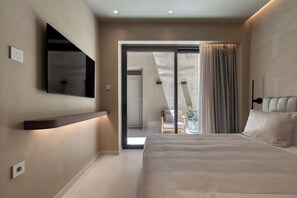 Ein modernes Schlafzimmer mit einem großen Bett, einem an der Wand montierten Fernseher und einer Glastür zum Balkon.