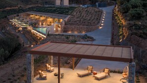 En modern villa med pool, utomhusmöbler och utsikt över de omgivande kullarna.