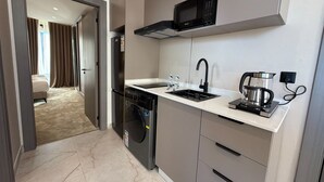Een moderne keuken met een ingebouwde magnetron, een koffiezetapparaat en een vaatwasser.