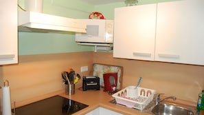 A kitchen with white cabinets, a microwave, a toaster, a sink, and a dish rack. - Apartment “Haus Am Fischbach” with Shared Terrace, Garden, and Wi-Fi (Waltershausen)