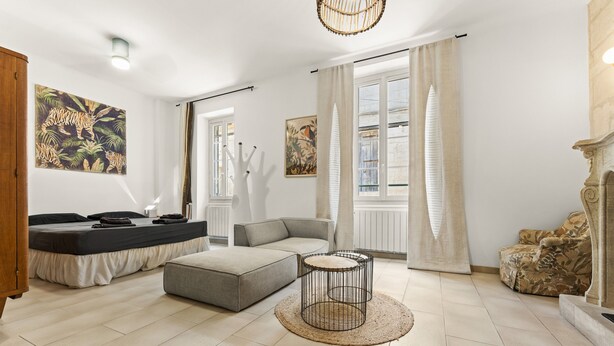 Ein modernes Wohnzimmer mit Sofa, Hocker und rundem Couchtisch.