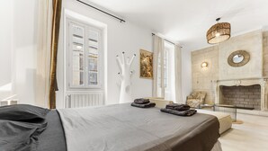 Ein Schlafzimmer mit einem Bett, einem Kamin und einem Fenster.
